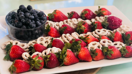 american flag made out of strawberries, yogurt covered pretzels and berries