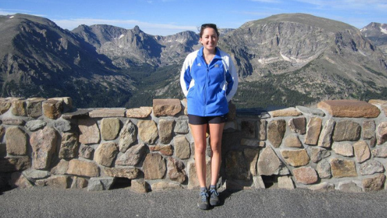 sarah posing in front of rock wall and mountains