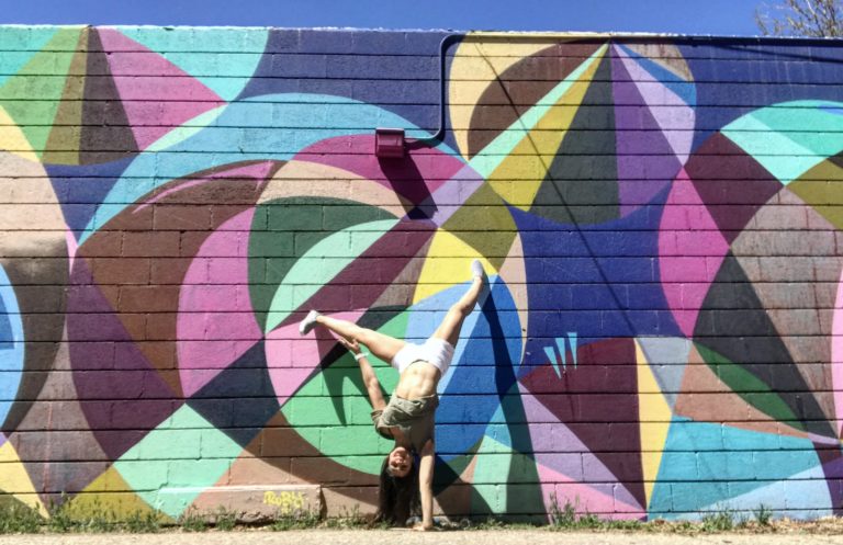picture of girl doing handstand in front of colorful background