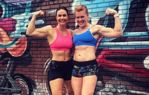 two female athletes flexing