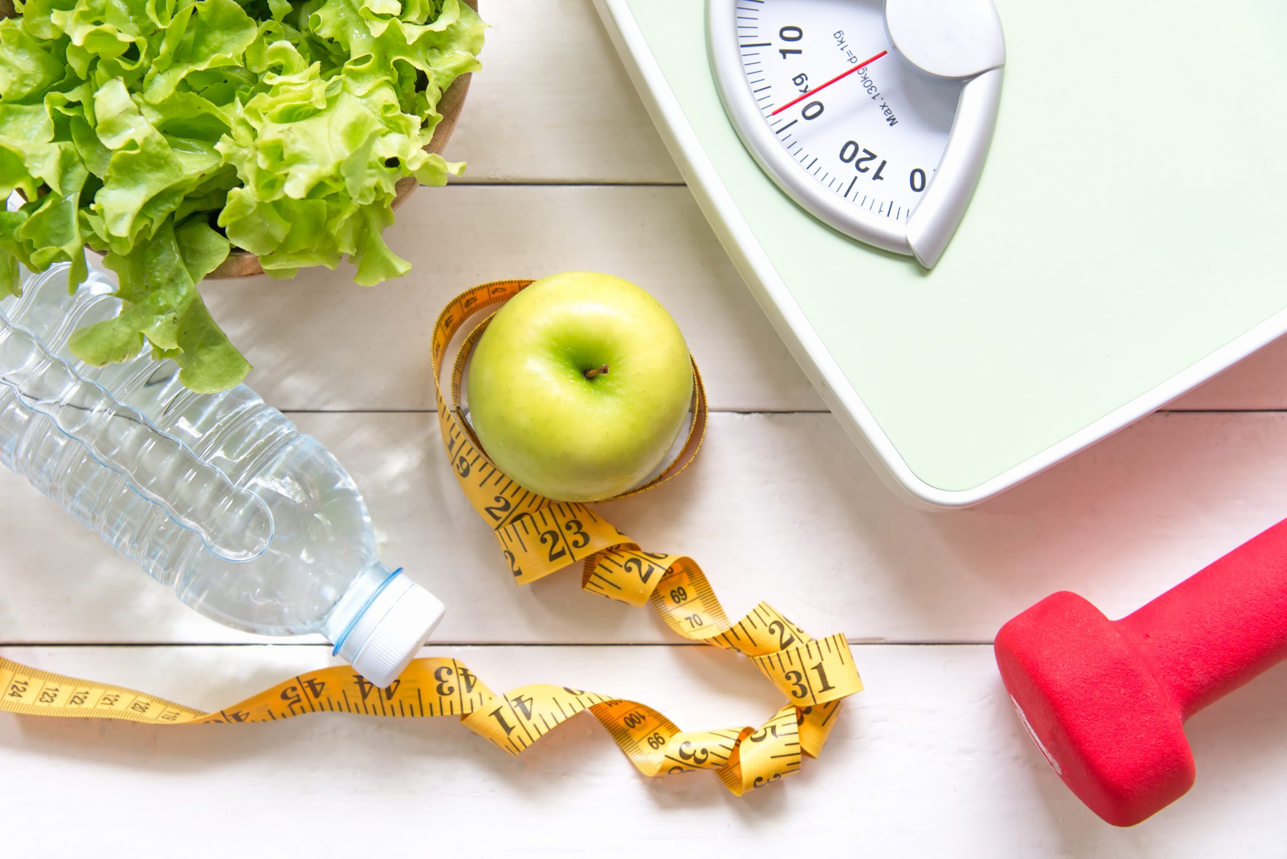 apple with measuring tape and weights surrounding it